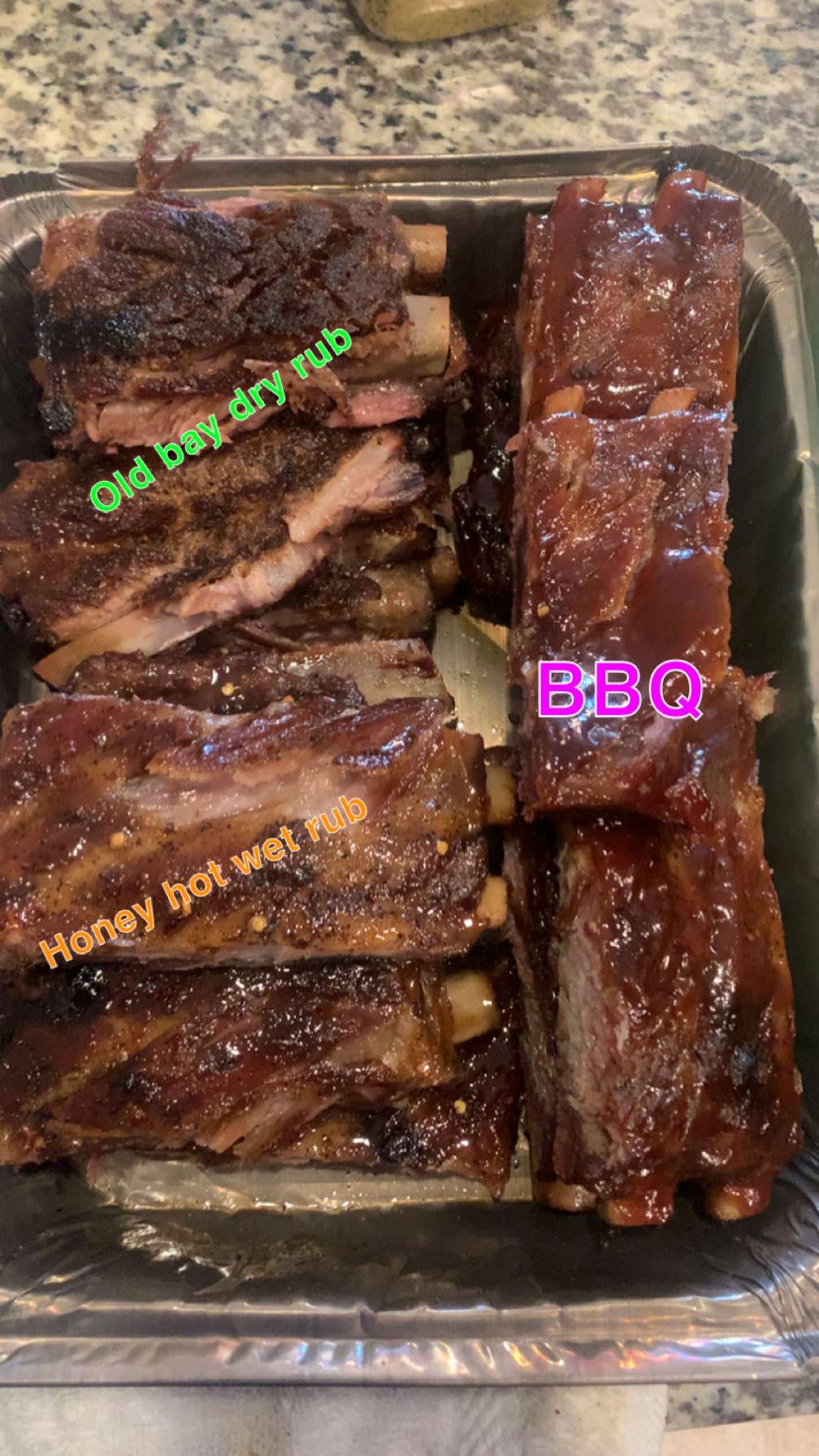 Pan of ribs in old bay dry rub, honey hot wet rub and BBQ