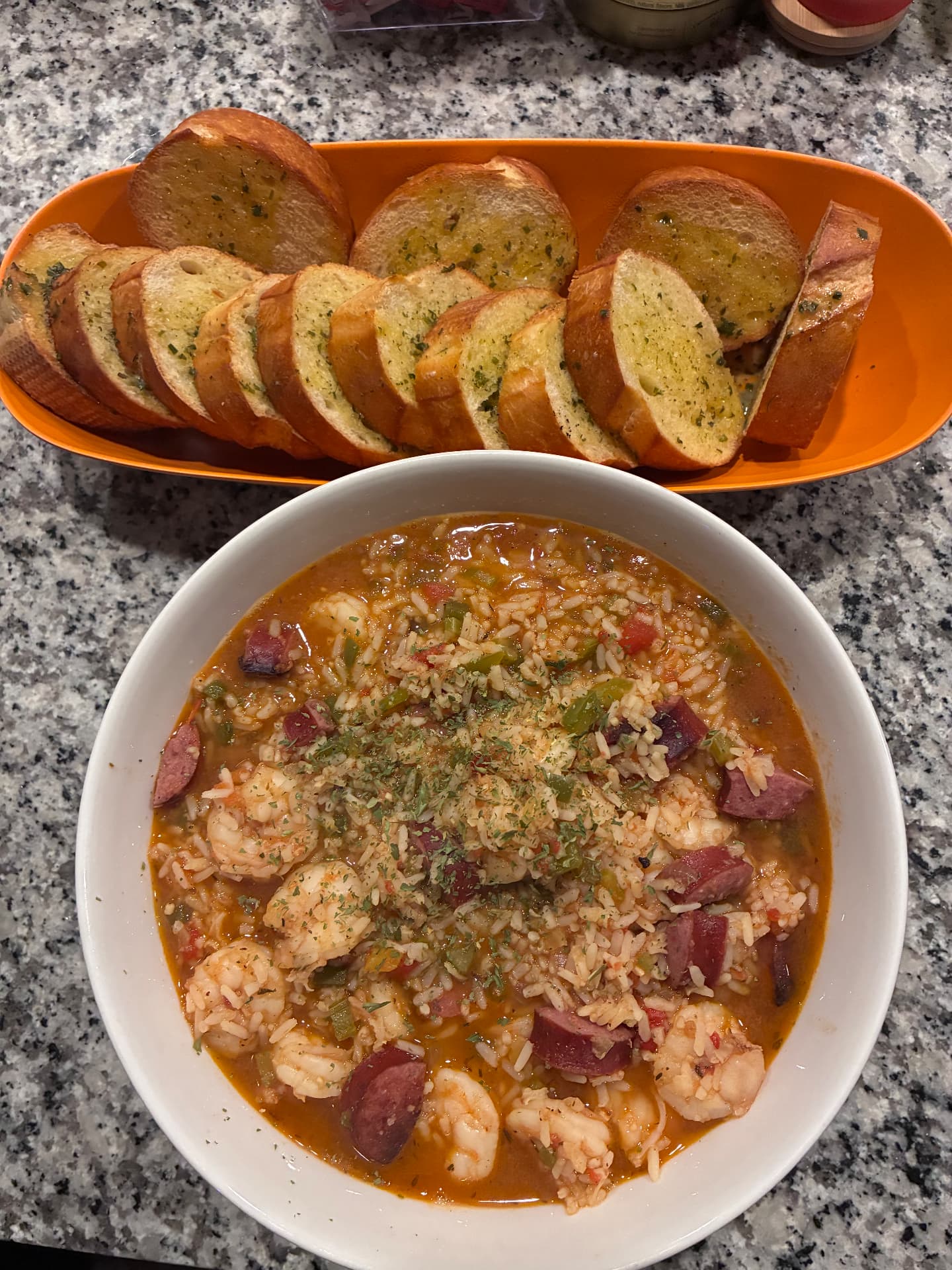 Bowl of shrimp and sausage jambalaya with sliced garlic bread