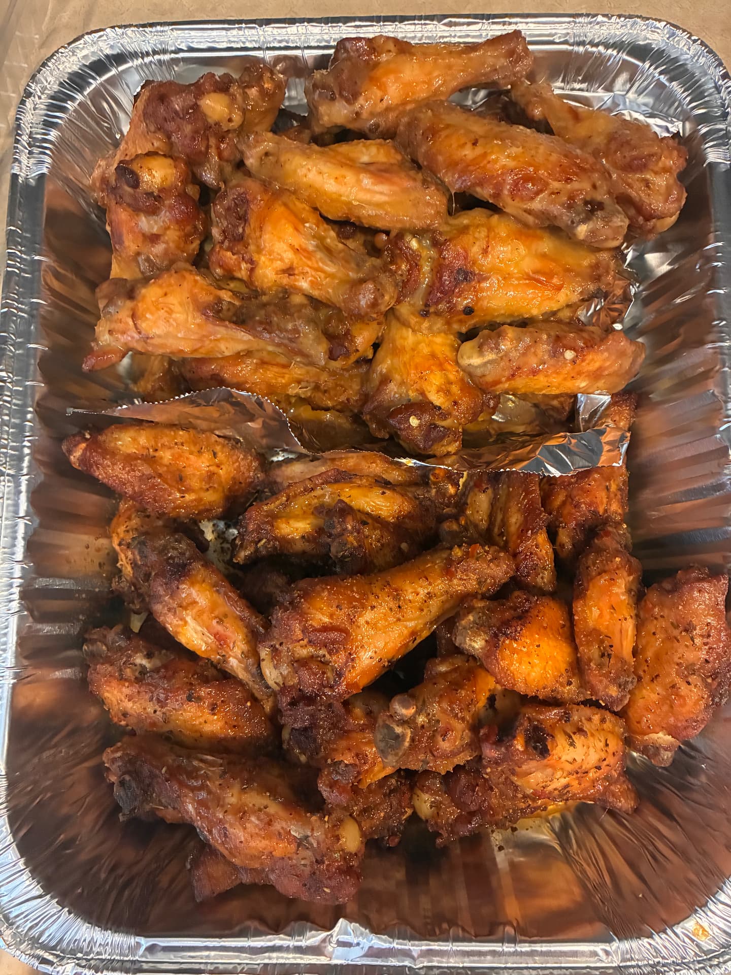 Foil tray of crispy dry-rubbed chicken wings